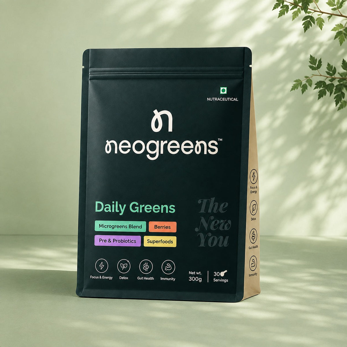 A black stand-up pouch of neogreens Daily Greens dietary supplement, displayed on a light beige surface with soft leaf shadows. The pouch features white branding and colorful accent labels indicating ingredients like microgreens blend, berries, pre & probiotics, and superfoods.